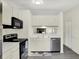 Kitchen with stainless steel appliances, white cabinets and view into the living room at 5821 Pemberly Dr, Indianapolis, IN 46221
