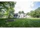 Back exterior of home highlighting the expansive backyard, sunroom and landscaping at 6028 Thornwood Ct, Indianapolis, IN 46250