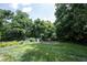Lush backyard with vibrant green grass, mature trees, and cozy garden at 6028 Thornwood Ct, Indianapolis, IN 46250