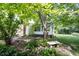 Secluded back yard showing the sun room, stone steps, and lush greenery at 6028 Thornwood Ct, Indianapolis, IN 46250