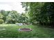 Beautiful backyard with lush green grass and fire pit, framed by mature trees at 6028 Thornwood Ct, Indianapolis, IN 46250