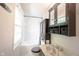 Bathroom with patterned sink, dark wood cabinets, and a shower-tub combo at 6028 Thornwood Ct, Indianapolis, IN 46250