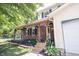 Charming front exterior showcasing a brick facade, covered porch with hanging plants, and a well-manicured lawn at 6028 Thornwood Ct, Indianapolis, IN 46250