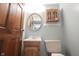 Cozy powder room with an oval mirror, wooden cabinet, and a wooden door at 6028 Thornwood Ct, Indianapolis, IN 46250