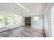Open-concept sunroom with hardwood floors, large windows, and light blue accent wall at 6028 Thornwood Ct, Indianapolis, IN 46250