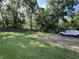 This backyard has a large lawn, storage sheds, playset, parking space, and mature trees at 6238 E Southport Rd, Indianapolis, IN 46237
