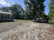 Large backyard featuring a deck, storage shed, and gravel driveway, offering ample space for outdoor activities at 6238 E Southport Rd, Indianapolis, IN 46237