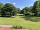 Enjoy the expansive backyard with lush green grass, mature trees, and a peaceful pond at 6238 E Southport Rd, Indianapolis, IN 46237