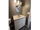 Bathroom vanity with cabinets and a round mirror at 6238 E Southport Rd, Indianapolis, IN 46237