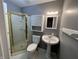 Bathroom with glass shower, pedestal sink and storage at 6238 E Southport Rd, Indianapolis, IN 46237