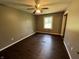 Bedroom with a ceiling fan, window, and wood floors at 6238 E Southport Rd, Indianapolis, IN 46237