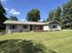 Attractive home showcases a lush green lawn and a charming exterior with well-maintained landscaping at 6238 E Southport Rd, Indianapolis, IN 46237