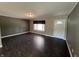 Neutral living room features modern flooring, a large window for natural light, and a white entry door at 6238 E Southport Rd, Indianapolis, IN 46237
