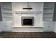 Bright living room with luxury vinyl flooring, white brick fireplace, and built-in shelving at 6238 E Southport Rd, Indianapolis, IN 46237
