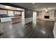 Open-concept living space with wood-look flooring, a fireplace, and seamless flow to the kitchen at 6238 E Southport Rd, Indianapolis, IN 46237
