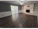 Bright living room with luxury vinyl flooring, fireplace, and sliding glass doors to sunroom at 6238 E Southport Rd, Indianapolis, IN 46237