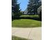 Well-manicured front yard with lush lawn and mature trees offering a glimpse of the white house at 6504 Potomac Square Ln, Indianapolis, IN 46268