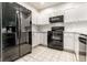 Kitchen showcasing black appliances, white cabinets, tile backsplash and tile flooring at 6592 Reserve Dr, Indianapolis, IN 46220