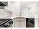 Kitchen details showcasing counter, stainless steel faucet, tile backsplash and black appliances at 6592 Reserve Dr, Indianapolis, IN 46220