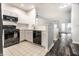 Bright kitchen featuring white cabinets, tile backsplash, black appliances and view of living room at 6592 Reserve Dr, Indianapolis, IN 46220