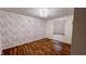 Bedroom with wooden floors, a light fixture and a wall with floral patterned wallpaper at 6602 S 400 W, Columbus, IN 47201