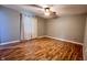Bedroom with laminate wood flooring, ceiling fan, curtains, and baseboard molding at 6602 S 400 W, Columbus, IN 47201