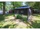 Quaint black exterior with a corrugated metal base surrounded by lush greenery and trees at 71 E Cove Ct, Cicero, IN 46034