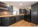 Modern kitchen featuring sleek black cabinets, wood countertops, stainless steel appliances, and stylish backsplash at 71 E Cove Ct, Cicero, IN 46034