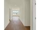 Hallway with attractive wood floors leading into a room with a large window at 7195 Rose Hill Ave, Brownsburg, IN 46112