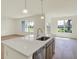 Kitchen island with a stainless dishwasher and sink, hardwood floors and natural light at 7195 Rose Hill Ave, Brownsburg, IN 46112