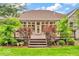 A spacious wooden deck overlooks a beautifully landscaped backyard with mature trees and shrubs at 720 Willow Pointe North Dr, Plainfield, IN 46168
