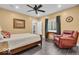 Cozy bedroom featuring wood-look tile flooring, ceiling fan, and a comfortable leather recliner at 720 Willow Pointe North Dr, Plainfield, IN 46168