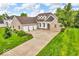 Beautiful brick home featuring an attached three-car garage and a well-manicured lawn with colorful flower beds at 720 Willow Pointe North Dr, Plainfield, IN 46168