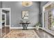 Spacious foyer with elegant hardwood flooring, showcasing artwork and a decorative rug, leading into the home at 720 Willow Pointe North Dr, Plainfield, IN 46168
