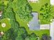 A high angle view of a well-maintained home with a driveway and a lush green lawn surrounded by mature trees at 7234 Fairwood Dr, Indianapolis, IN 46256