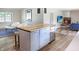 Open floor plan featuring kitchen with island, beverage cooler, and an adjacent living room with fireplace at 7234 Fairwood Dr, Indianapolis, IN 46256