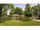 Charming ranch-style home featuring a well-manicured lawn and mature trees in a desirable neighborhood at 7401 N Layman Ave, Indianapolis, IN 46250