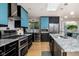 Modern kitchen featuring stainless steel appliances, sleek black cabinetry and tile backsplash at 7401 N Layman Ave, Indianapolis, IN 46250