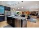 Modern kitchen with a stainless steel island, bar seating, and an open layout to the dining area at 7401 N Layman Ave, Indianapolis, IN 46250