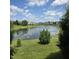 Serene backyard view featuring a pond, green space and picturesque landscaping at 7608 Mather Ln, Indianapolis, IN 46239