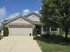 Charming home showcasing a well-manicured lawn, complemented by a spacious two-car garage at 7608 Mather Ln, Indianapolis, IN 46239