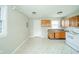 Kitchen with white appliances, laminate flooring, and wood cabinets at 8210 Patton Dr, Lawrence, IN 46226
