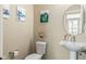 Stylish half-bathroom featuring modern fixtures, elegant artwork, pedestal sink and mirror in neutral tones at 830 Freeland Way, Carmel, IN 46032