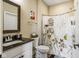 Bathroom with a framed mirror, neutral walls, and a combined shower and bathtub with a floral shower curtain at 830 Freeland Way, Carmel, IN 46032