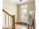 Bright entryway with hardwood floors, a staircase, and a glass-paneled front door at 830 Freeland Way, Carmel, IN 46032