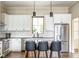 Stylish kitchen with white cabinets, stainless steel appliances, and an island with barstool seating at 830 Freeland Way, Carmel, IN 46032