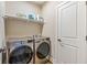 Laundry room featuring stainless steel washer and dryer and storage shelves with cleaning supplies at 830 Freeland Way, Carmel, IN 46032