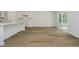 Open kitchen area with white cabinets, and hardwood floors leading to a bright patio space at 8344 Leander Ave, Zionsville, IN 46077