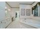 Well-lit bathroom with a soaking tub, double vanity, and a large mirror at 9190 Hastings Trce, Indianapolis, IN 46234