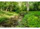 A serene creek flows through the backyard, surrounded by lush greenery, adding a natural touch to the landscape at 9190 Hastings Trce, Indianapolis, IN 46234